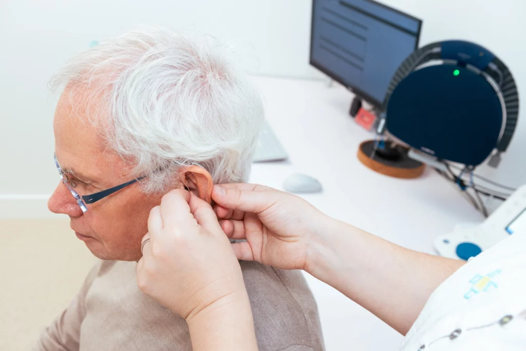 A man having his ear looked at by an audiologist