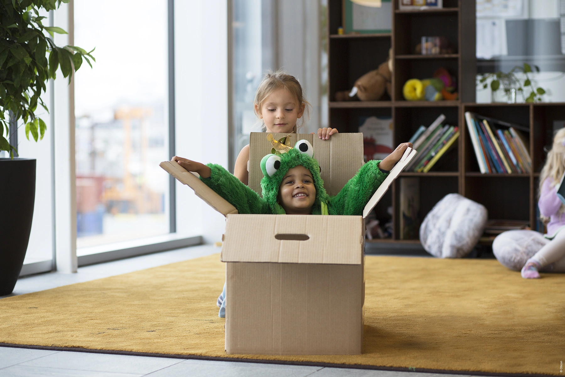 Two children playing inside a box